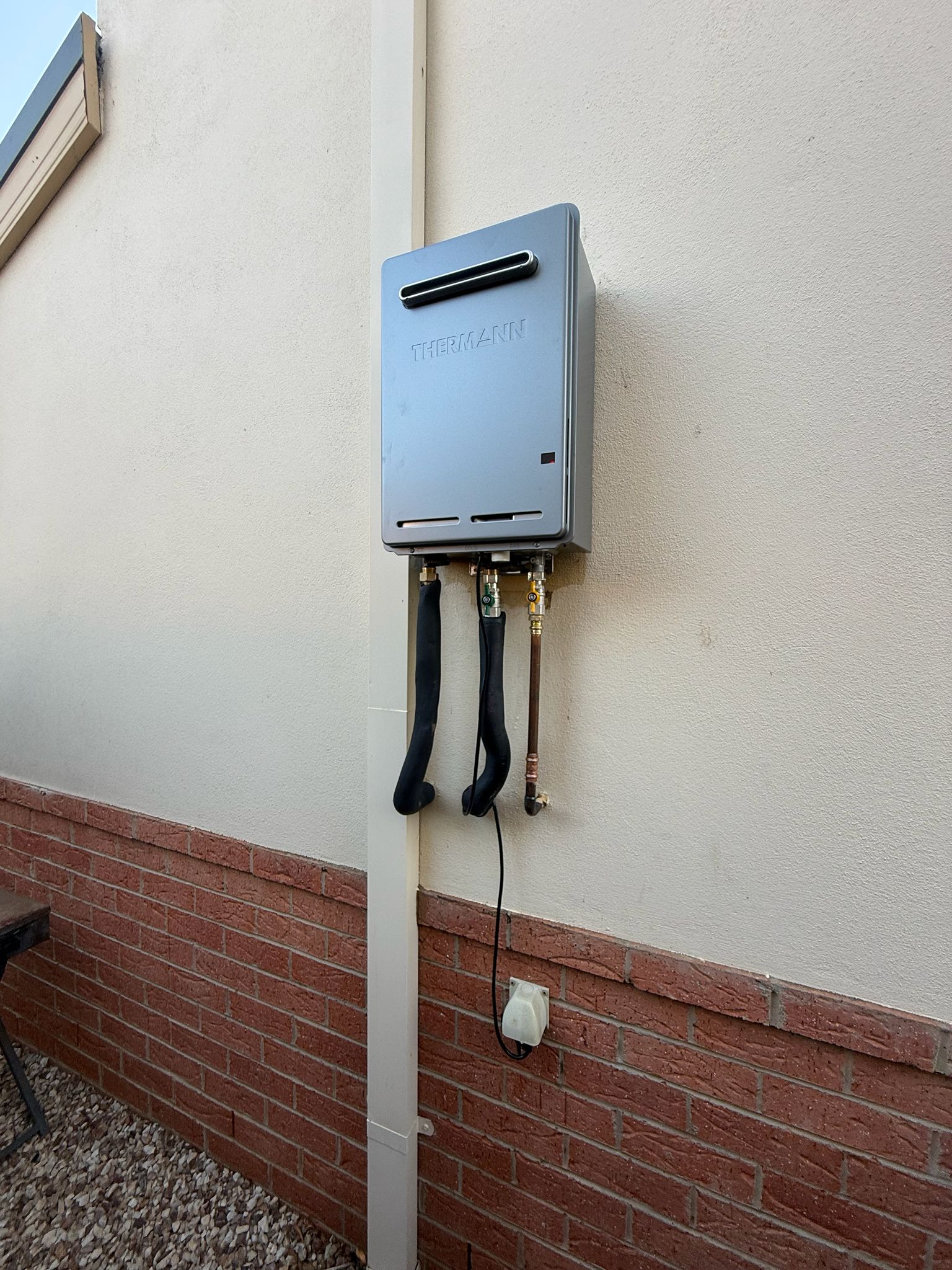 Continuous flow hot water system installed on external rendered wall Williamstown Melbourne